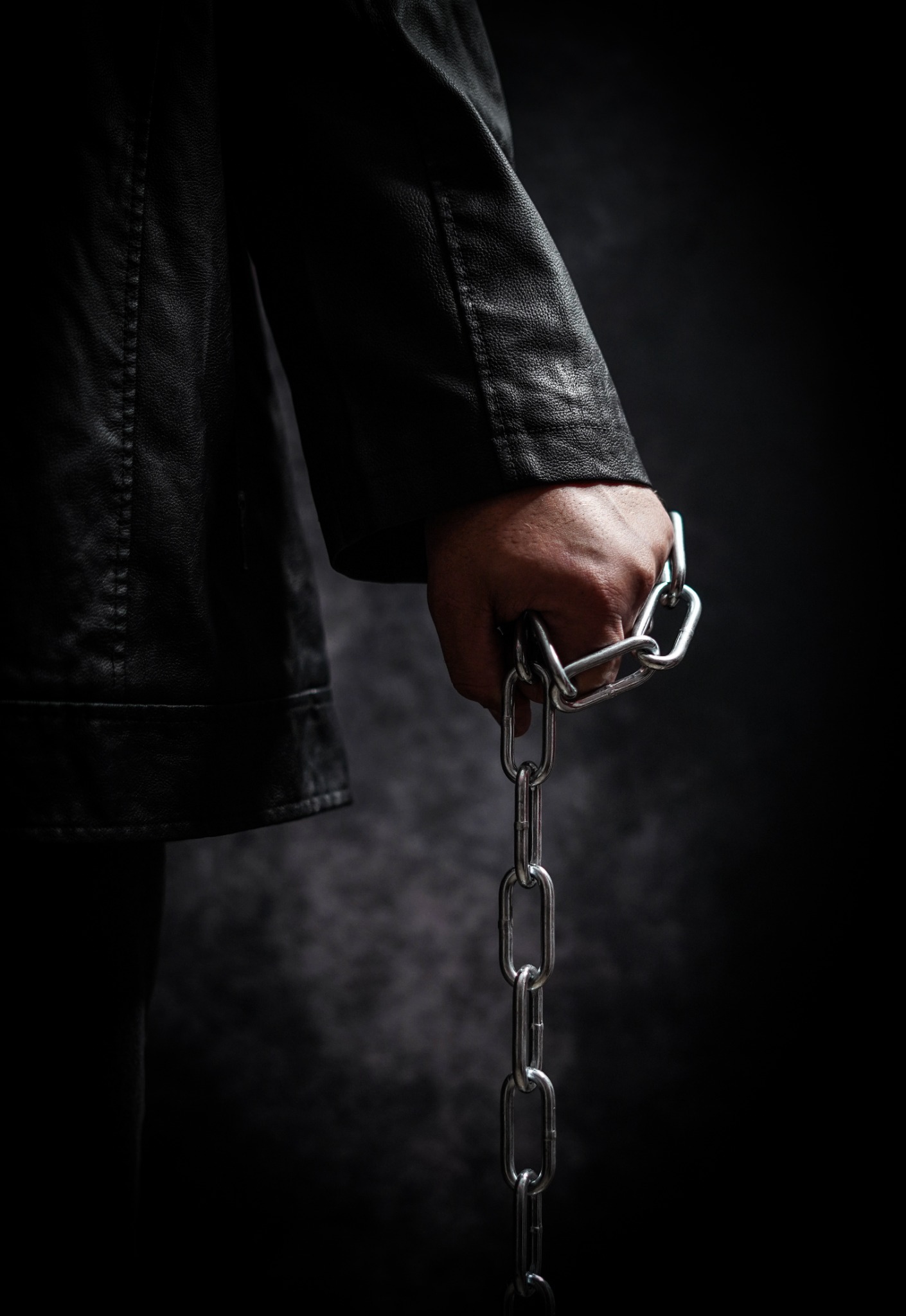 Männliche Hand mit Kette als Symbol für dominante Führung